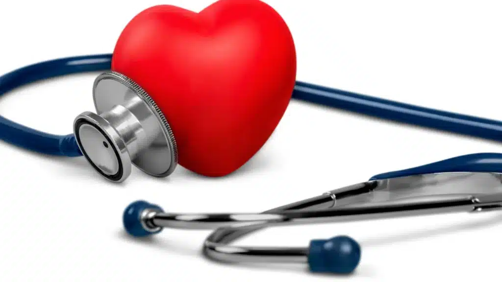 A red heart and a stethoscope resting on a white surface.
